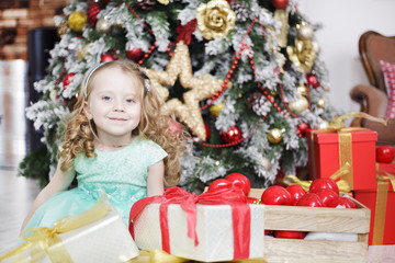 Fototapeta na wymiar Christmas, beautiful blond girl near Christmas tree, with gifts