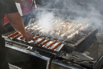 Meat grilled on skewers, brazier under the hood of the car