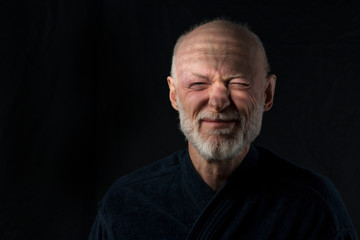 Obraz premium portrait of senior just awakened man in bathrobe on black background