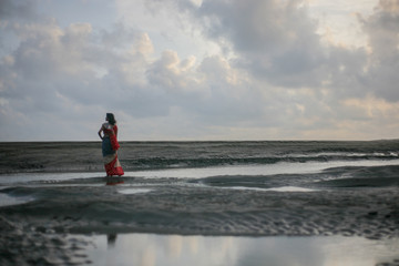 Fototapeta na wymiar girl in saree standing on the beach