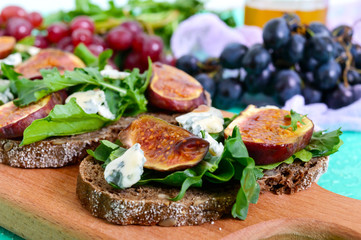 Useful sandwich with figs, blue cheese, arugula, balsamic on whole wheat bread. Healthy eating.