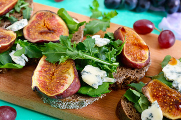 Useful sandwich with figs, blue cheese, arugula, balsamic on whole wheat bread. Healthy eating.