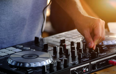 DJ plays and mix music on digital midi controller.