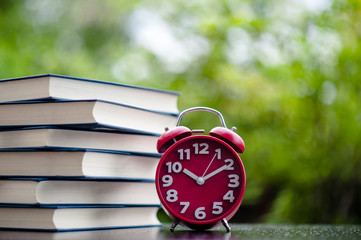 Books and red clocks. Put on the floor. White leather Book and study The concept of empathy and...