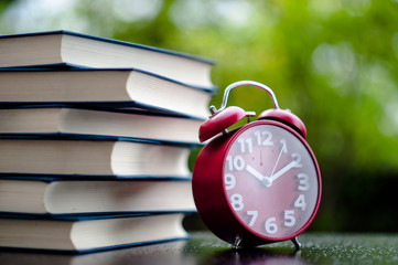 Books and red clocks. Put on the floor. White leather Book and study The concept of empathy and development