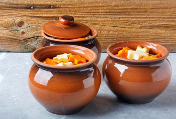 Traditional rustic home vegetable  ragout in three clay pots on beautiful  table top.