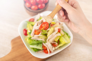 Fresh and delicious homemade chicken salad with tomatoes and pomelos in wooden background, concept of healthy and diet, top view, copy space