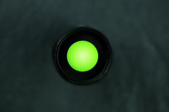 An Overhead Photo Of A Vibrant Green Button On A Dark Panel With Copy Space