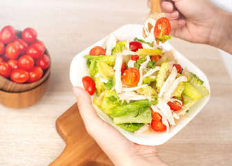Fresh and delicious homemade chicken salad with tomatoes and pomelos in wooden background, concept of healthy and diet, top view, copy space