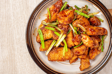 Delicious homemade stewed fish slices with scallion in wooden background, Taiwan delicacies, top view, copy space