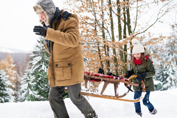 Grandfather and small girl in snow on a winter day.