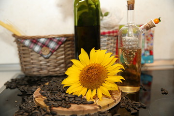 sunflower seed oil in a glass bottle with natural seeds and a sunflower flower style of life