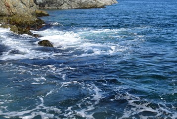 rugged shoreline blue ocean surface with light surf swell 