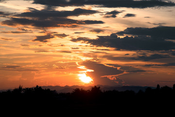 Obraz premium View of orange sunlight and dark clouds and mountain in evening time