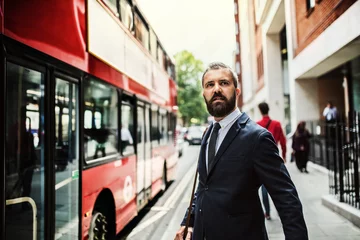 Rolgordijnen Hipster zakenman staande op straat, wachtend op de bus in Londen. © Halfpoint