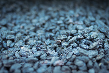 Background of dark raisins, dried grapes close-up in defocus