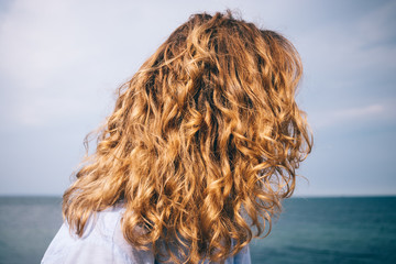 Back view female's head on blue sea background