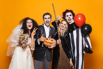 Group of cheerful friends dressed in scary costumes c