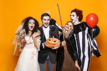 Group of excited friends dressed in scary costumes