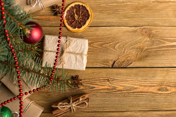 Craft gifts under the tree, on the table, against the wood background. The concept of Christmas and New Year.