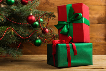 Green red gifts under the tree, on the table, against the wood background. The concept of Christmas and New Year.