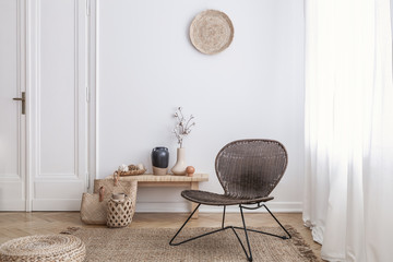 Modern armchair and pouf on brown carpet in white apartment interior with door. Real photo - obrazy, fototapety, plakaty
