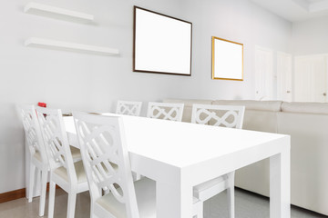 table with picture frames in a white room