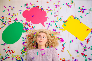 New idea. Curly blond excited woman lying with colorful confetti at the head of the new ideas in the form of three empty colorful bubbles for text, on white background. Seria with different emotions.