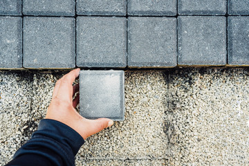 Paving blocks. Hand holds and install paving block