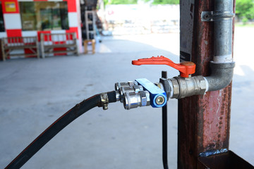 the pressure valve for mechanic job connect with iron tube  with rusty metal pole at car repair shop