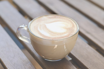 Cup of cappuccino on a wooden table.