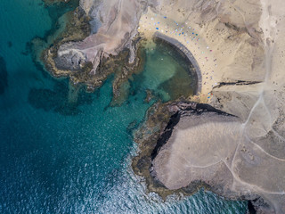Vista aerea delle coste frastagliate e delle spiagge di Lanzarote, Spagna, Canarie. Strade e sentieri sterrati. Bagnanti in spiaggia. Oceano Atlantico. Papagayo