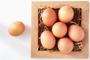 Chicken brown eggs on a white table