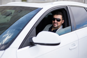 portrait of handsome business man driving his car