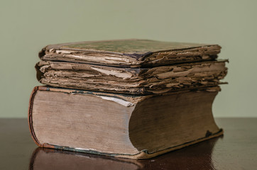 Ancient medieval worn books with yellow sheets stacked on a table