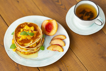Pancakes with honey and fruit. Delicious breakfast.