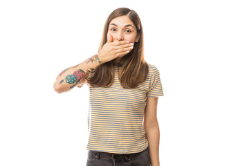 Woman Covering Mouth In Shock Against White Background