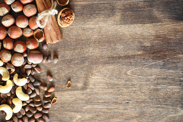 Different nuts on a wooden table. Cedar, cashew, hazelnut, walnu
