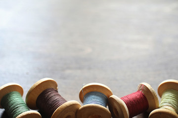Sewing thread on a wooden background. Set of threads on bobbins 