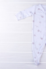 White baby pajama sleepwear on wood.