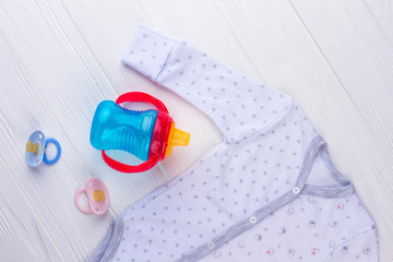 Blue baby bottle, pacifiers and clothes.