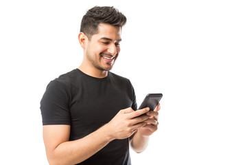 Man Smiling And Social Networking On Smartphone Over White Background