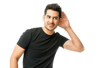 Young Man Holding His Hand Near Ear And Listening Carefully