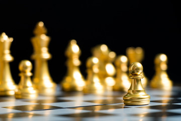 Gold pawn is on the first move in chess game on black background (Concept for business decision, start or beginning project) - obrazy, fototapety, plakaty