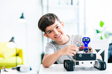 Joyful schoolboy involved in modern robotic engineering