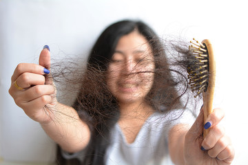 Hair loss, hair fall everyday serious problem, girl with a comb and problem hair on white...