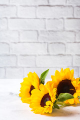 Background with fresh yellow sunflowers on a white kitchen table