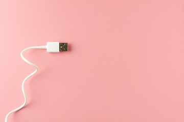 Fototapeta premium white USB cable on pink background.