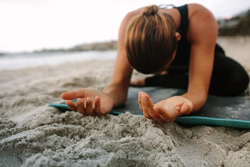 Woman doing yoga at the beach