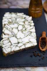 Chicken roll on a black plate.